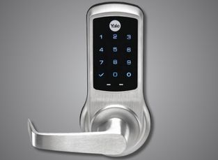 A sleek Yale smart door lock with a touchscreen keypad and integrated deadbolt, connected via Wi-Fi for remote access.