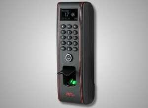 A ZKTeco fingerprint scanner with a metallic sensor and LCD interface for biometric entry.